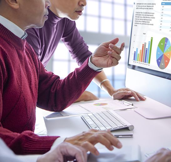 people looking at charts on a computer
