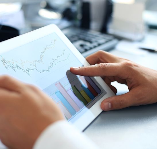 person holding ipad with charts