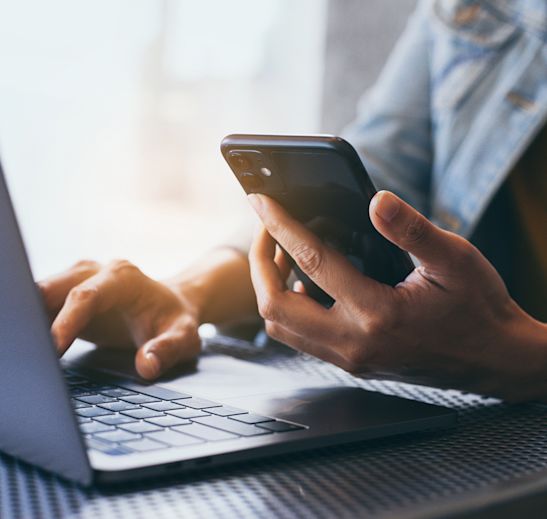 a person working on a phone and computer