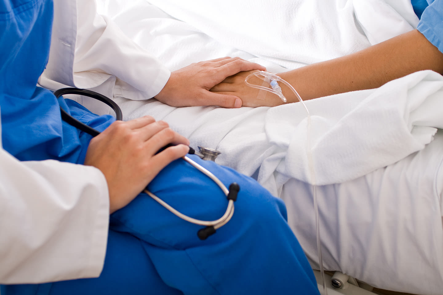 A doctor holding a patient's hand