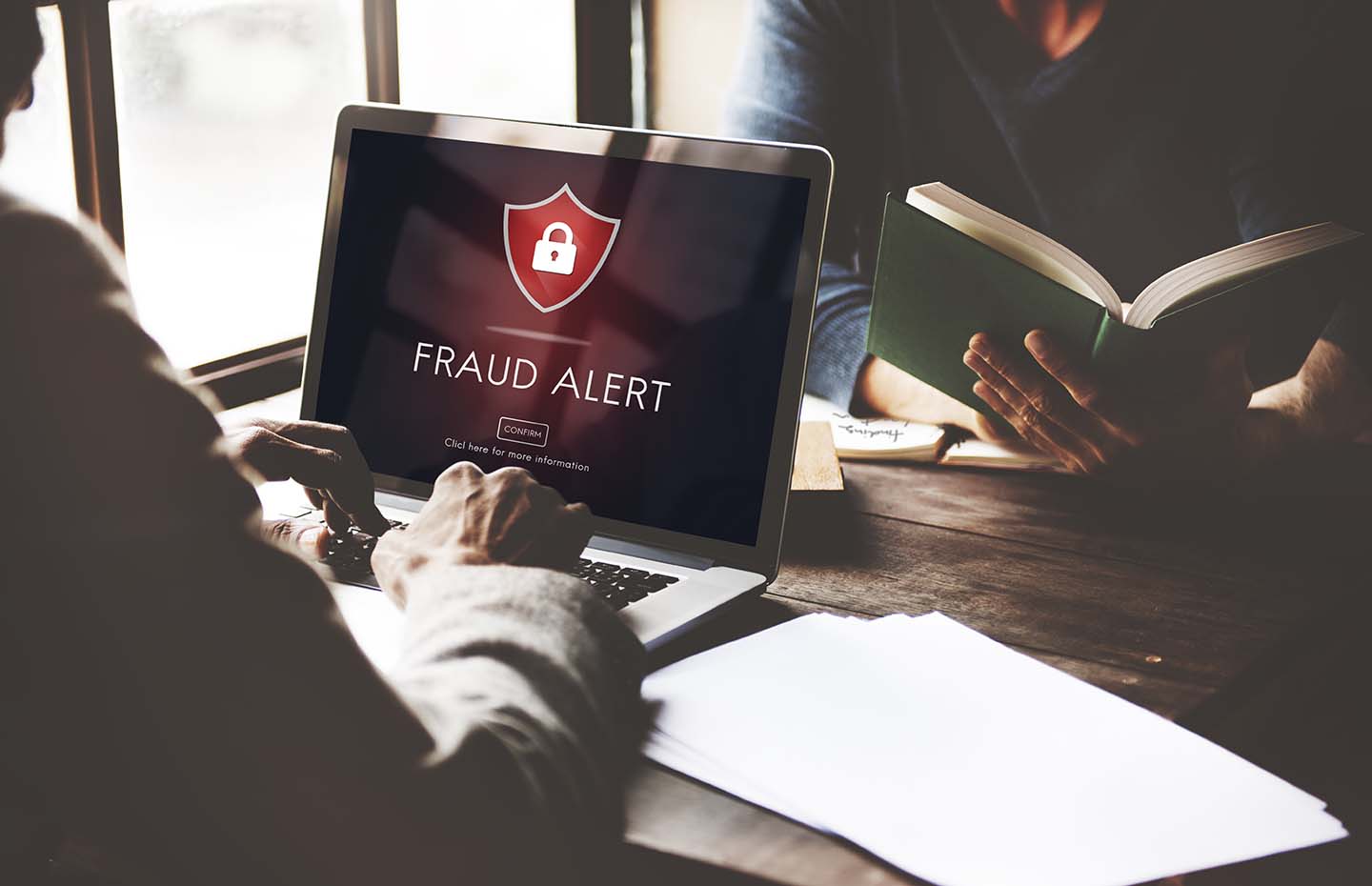 person at a computer receiving a fraud alert warning