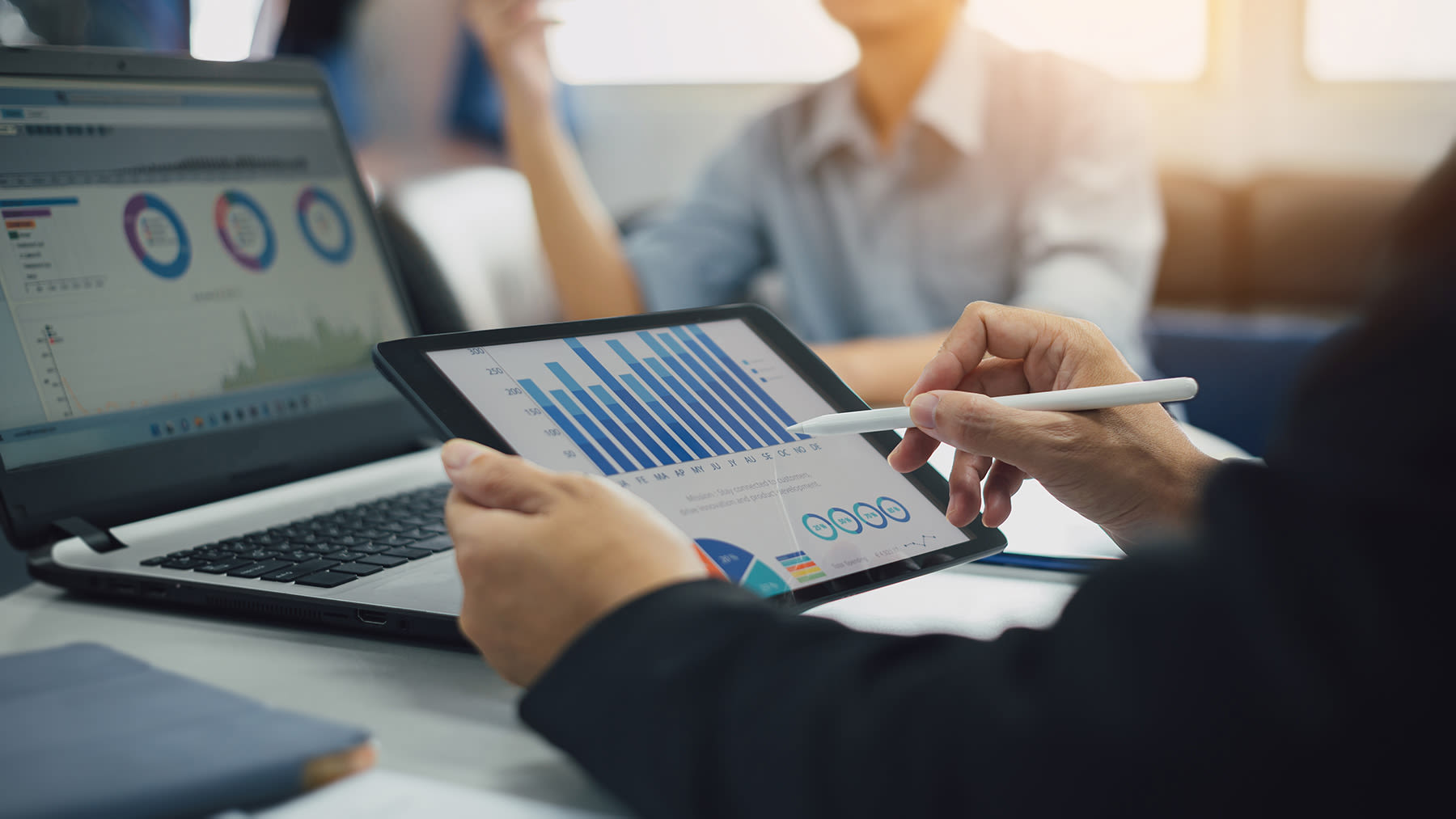 person using a stylus on a tablet looking at charts