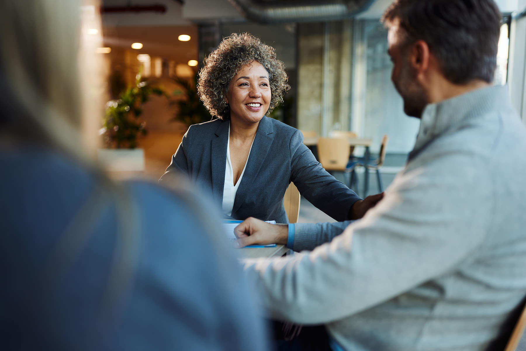 Woman in a suit speaking with a business owner about an SBA business acquisition loan