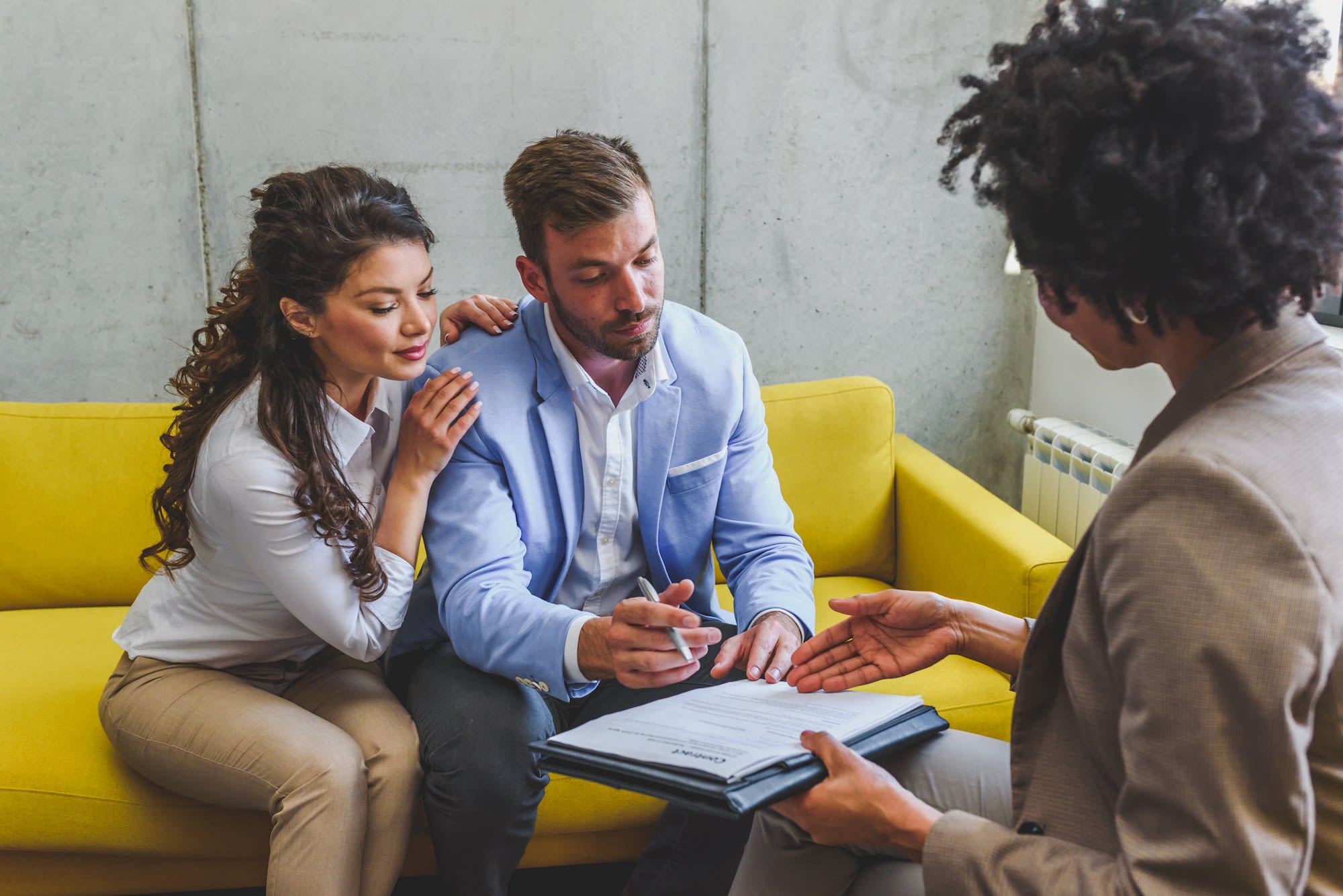 Young married couple signing papers after consulting with a professional CPA