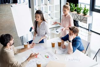 a business meeting where 4 individuals are discussing at a table