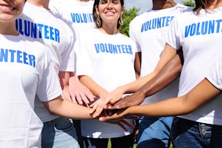 a group of volunteers putting their hands together