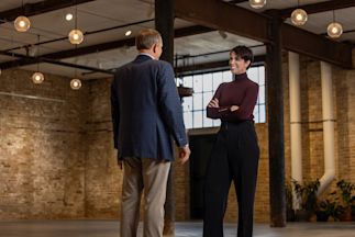 Niamh Kristufek standing in an open indoor space talking with someone