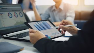 person using a stylus on a tablet looking at charts