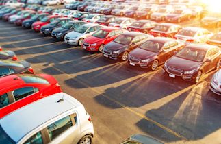 car lot full of cars with the sun shining on them