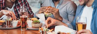 3 guys eating burgers and drinking beer