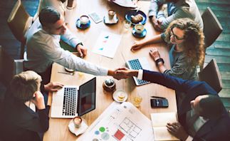 group of coworkers collaborating at a large desk