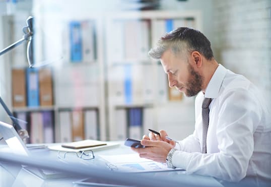 man at a desk on a phone