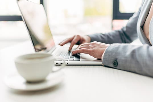 woman typing laptop to assist with commercial lending inquiry