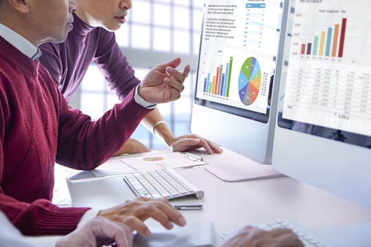 people looking at charts on a computer