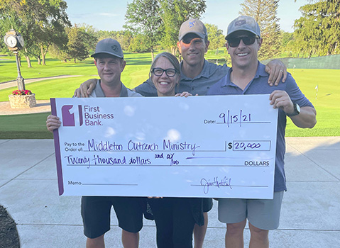 Four people holding a large $20,000 check written out to Middleton Outreach Ministry