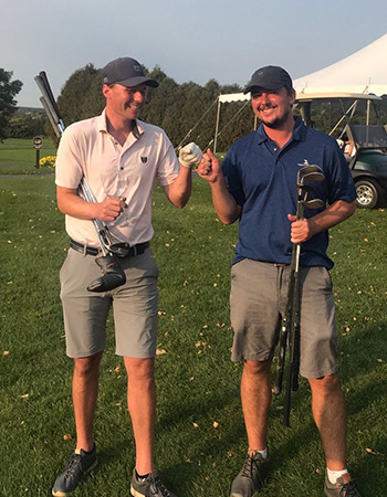 two golf players smiling and bumping fists