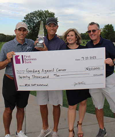 four people holding a large $20,000 check written out to Garding Against Cancer