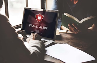 person at a computer receiving a fraud alert warning