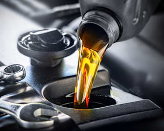 close up of oil being poured into a machine
