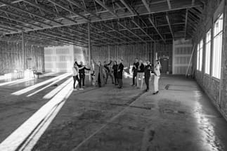 A team celebrating and posing for the camera in an under construction vet hospital