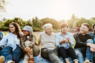 A group of people sitting closely together outdoors.